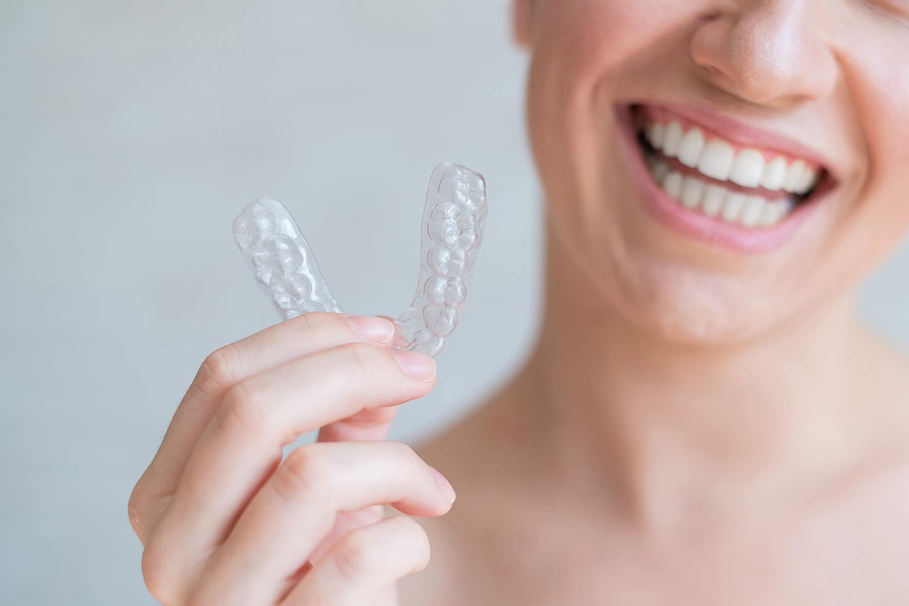 Woman smiling with clear dental aligners in Highlands Ranch, CO